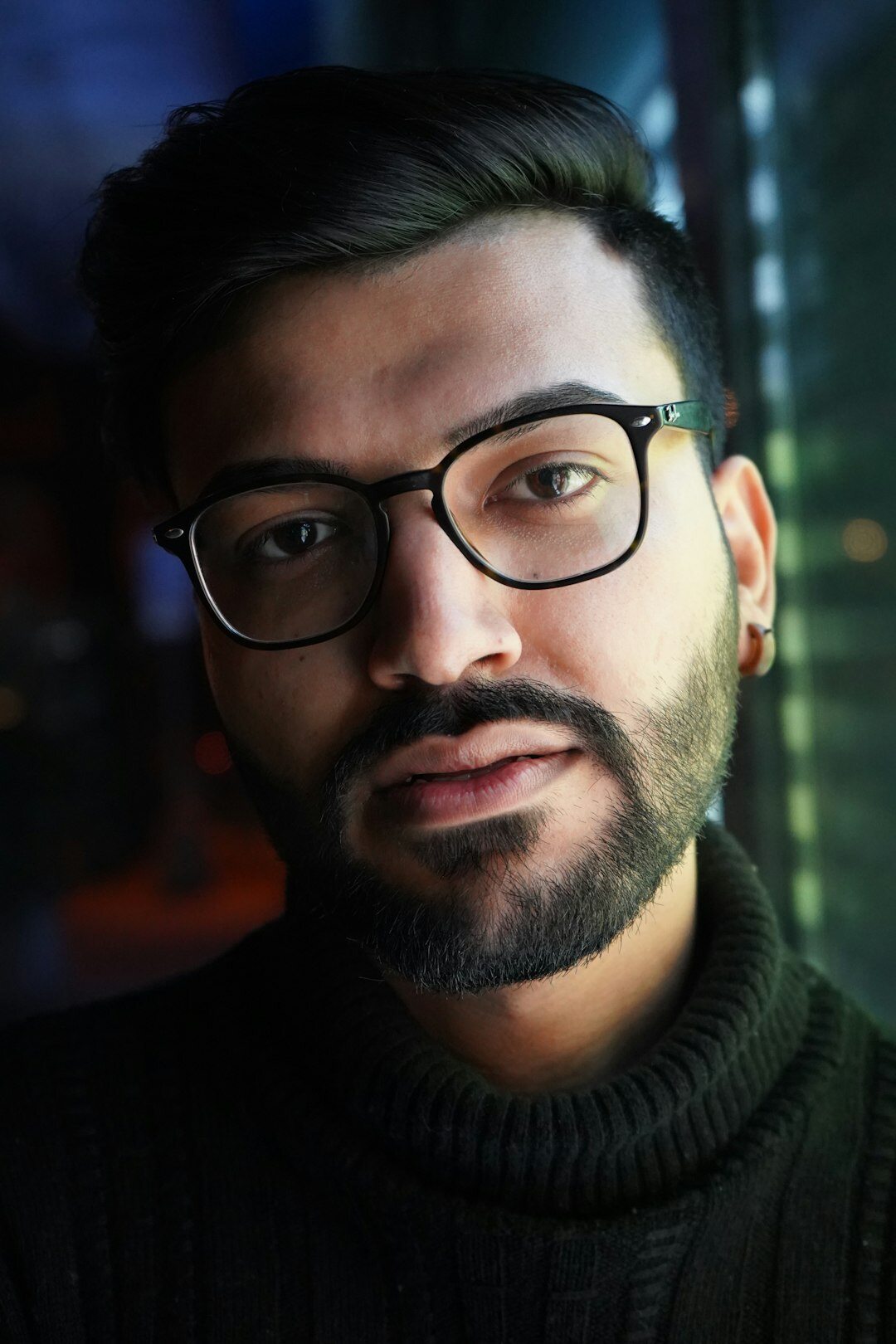 Portrait of a man with a short beard and glasses